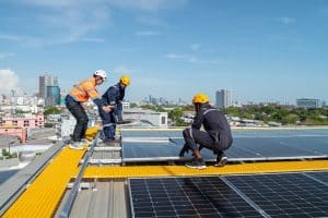 Engineers and technicians check drawings for installing solar cell panels on the roof. alternative energy energy from the sun
