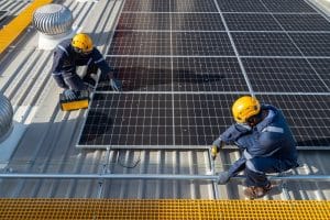 Engineers and technicians check drawings for installing solar cell panels on the roof. alternative energy energy from the sun