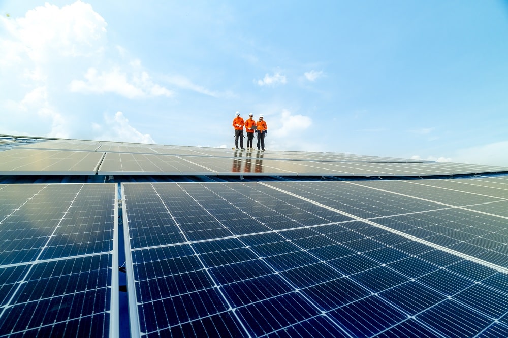 engineer man inspects construction of solar cell panel or photovoltaic cell by electronic device. Industrial Renewable energy of green power. factory worker working on tower roof.