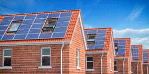 Row of house with solar panels on roof  on blue sky background. 