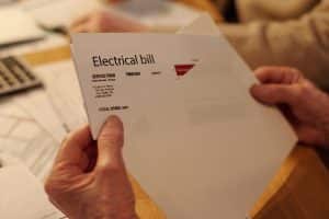 holding an envelope with electrical bill details